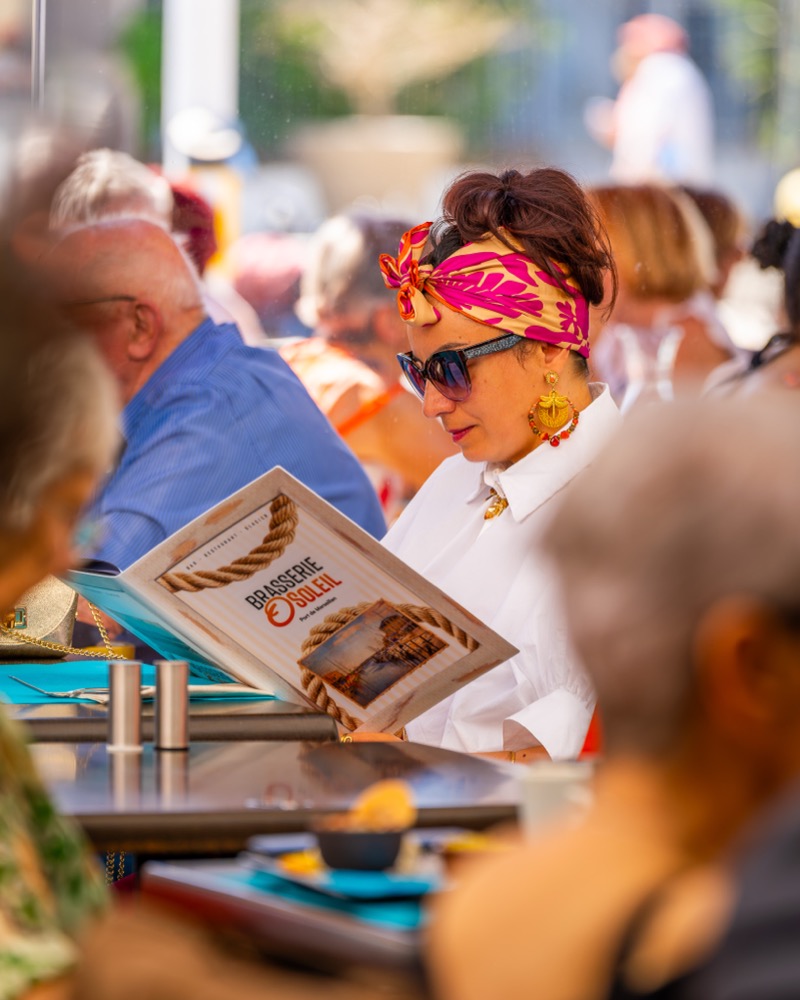 Cliente consultant la carte sur la terrasse O'Soleil