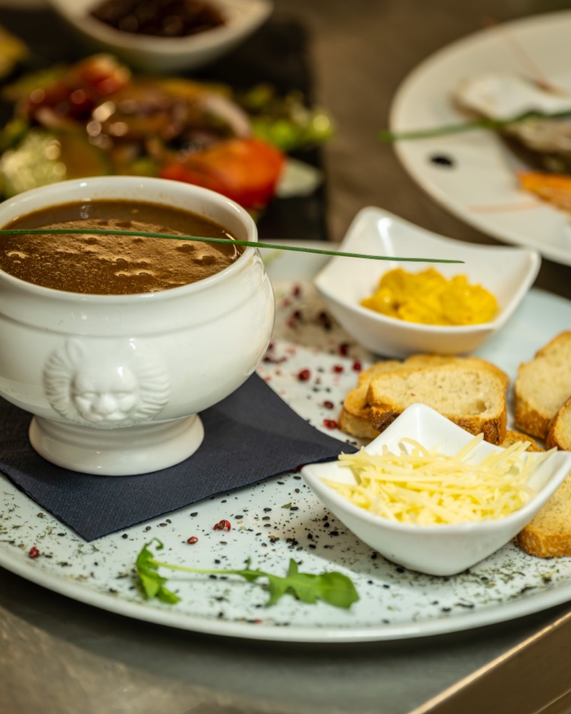 Soupe de poissons servie avec rouille, croûtons et fromage